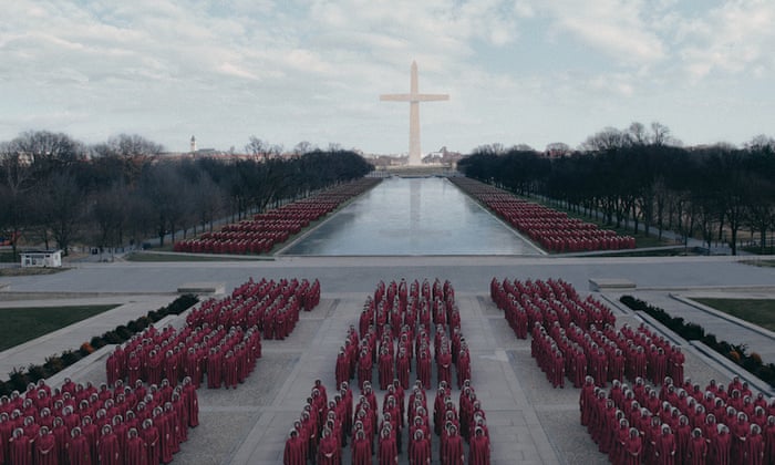 Washington DC in the Republic of Gilead, where the Washington Monument has been replaced with a cross, thousands of uniformed Handmaids are assembled