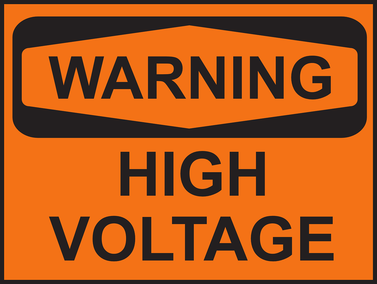 A sign in black letters on an orange background. It says: 'Warning - High Voltage'.