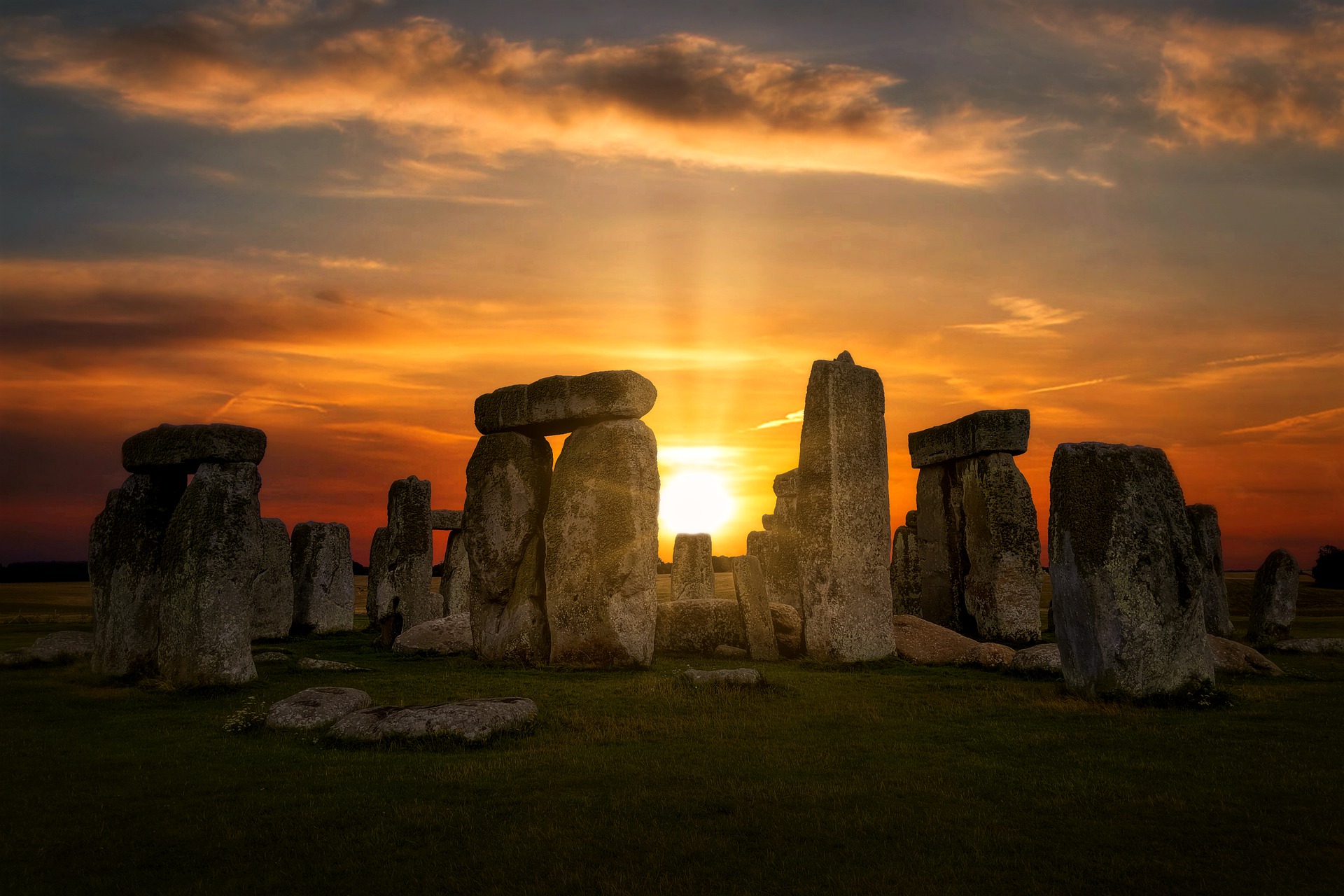 The sun is rising through Stonehenge