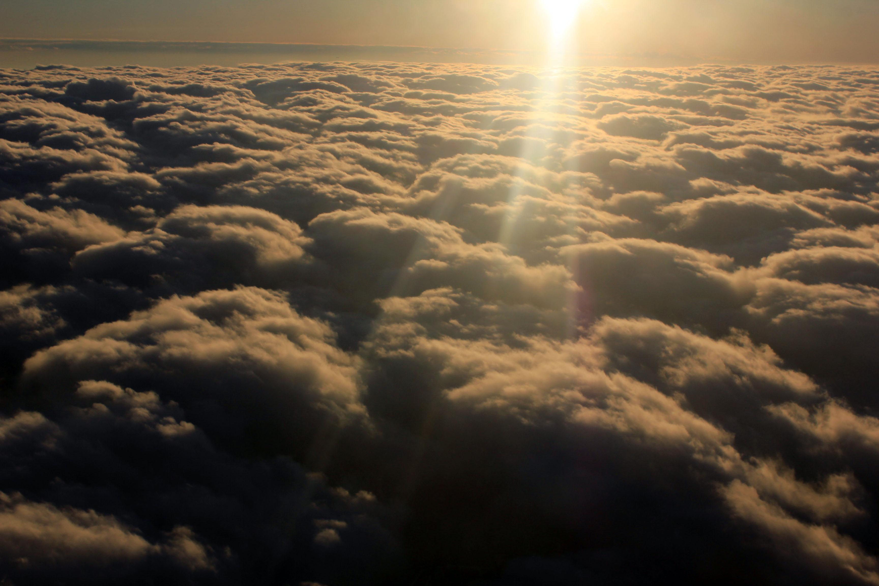 Powerful sun above a blanket of clouds
